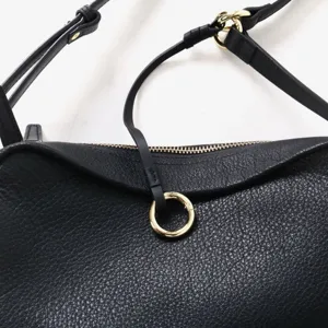 Vue détaillée du sac à bandoulière en cuir noir, sac souple élégant avec quincaillerie dorée.