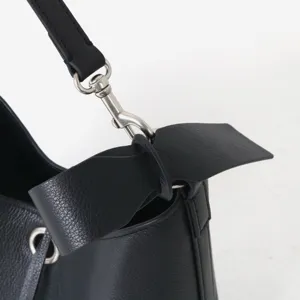 Vue détaillée du sac seau en cuir véritable noir avec quincaillerie en métal et connecteur.