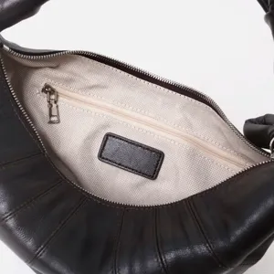 Vista detallada del interior del bolso hobo de cuero marrón con bolsillo con cremallera.