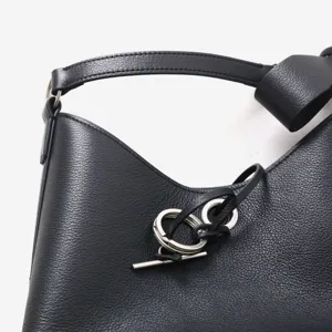 Sac porté épaule en cuir noir avec fermeture élégante à anneau en métal et texture grainée.
