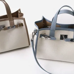 Détail cabas en toile et cuir véritable, options de couleur bleu et marron, sac élégant.