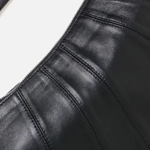 Vista de cerca de bolso hobo de cuero negro con textura de costura fina y cremallera metálica.