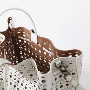 Vue détaillée du grand sac seau en cuir blanc découpé au laser et quincaillerie