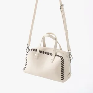 Vue détaillée du sac à main Boston en cuir beige avec de superbes coutures tressées.