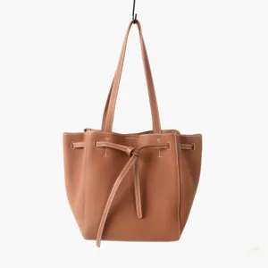 Vue détaillée du sac cabas marron en cuir véritable avec cordon de serrage et poignées élégantes.
