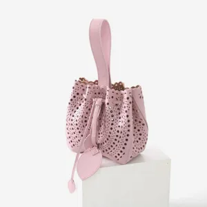 Sac seau en cuir rose découpe laser, élégant sac à main avec poignée et cordon serré.