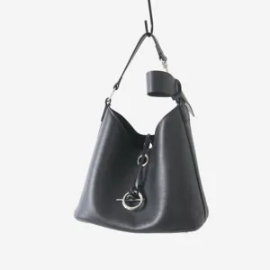 Détail de sac seau noir en cuir de vachette grainé avec une fermeture à anneau métallique.