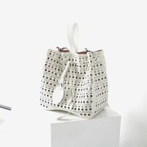 Sac seau en cuir blanc ajouré avec poignée supérieure et cordon de serrage pour femme.