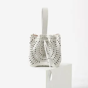 Sac seau en cuir blanc élégant avec un design perforé et ajouré découpé au laser.