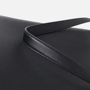 Primo piano dettagliato di cinturino per borsa in pelle nera con cuciture pregiate.