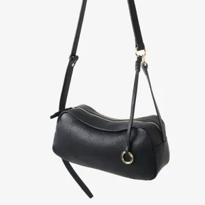 Vue de détail rapprochée du sac boston en cuir véritable noir avec finitions dorées.
