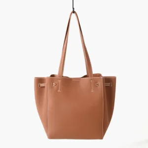 Détail de sac cabas en cuir marron, double poignées, surpiqûres blanches, sangles.