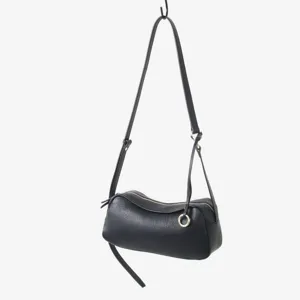 Détail de sac bandoulière toast en cuir noir, cuir souple avec anneau métallique doré.
