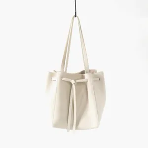 Vue détaillée du sac à main en cuir véritable montrant une texture fine et un élégant nœud.