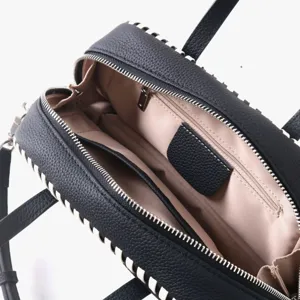 Vue détaillée de l'intérieur du sac boston en cuir noir avec doublure beige et coutures.