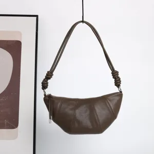 Vue détaillée du sac porté épaule croissant en cuir marron avec bandoulière nouée.