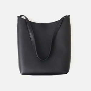Dettaglio borsa a spalla minimalista in pelle nera, elegante borsa a secchiello hobo.
