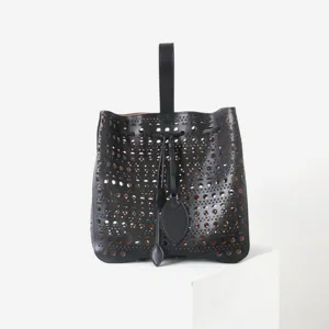 Vue détaillée du grand sac à main en cuir noir ajouré avec une découpe laser élégante.