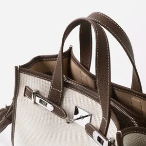 Sac cabas en toile et cuir avec détail de serrure en métal, sac à main classique pour femme.