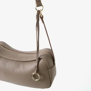 Vue rapprochée détaillée du sac Boston toast en cuir grainé taupe avec anneau métallique.