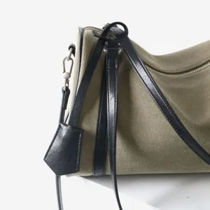 Vue détaillée du sac à bandoulière en toile et cuir avec lanières noires et design.