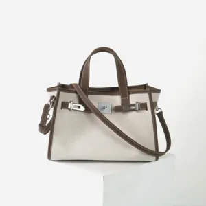 Sac à main en toile et cuir, élégant cabas de travail avec fermoir en métal et bandoulière.