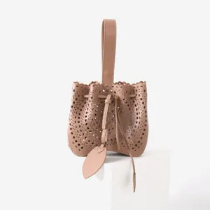 Vue détaillée du sac seau en cuir ajouré mettant en valeur ses motifs de découpe laser.