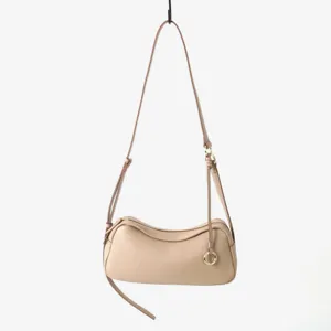 Gros plan sur le sac à épaule en cuir beige montrant la texture grainée et la fermeture éclair.