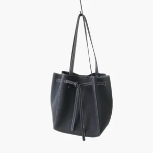 Sac cabas seau en cuir noir, design minimaliste à cordon, vue détaillée élégante.