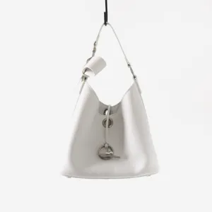 Détail de sac seau en cuir blanc véritable avec anneaux argentés élégants et fermoir chic.