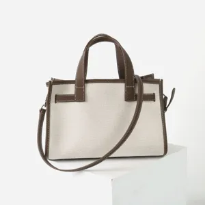 Sac cabas fourre-tout pour femme en toile et cuir veritable avec poignees et bandouliere.