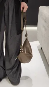 Sac bandoulière croissant en cuir véritable avec lanière nouée et fermeture éclair.