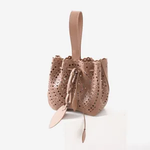 Élégant sac seau en cuir avec motifs géométriques ajourés et poignée supérieure.