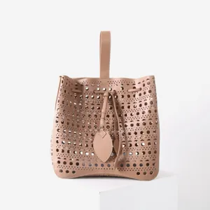 Vue détaillée du sac seau en cuir beige doté de superbes motifs géométriques découpés.
