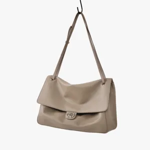 Gros plan détaillé sur le sac porté épaule en cuir taupe avec fermoir métallique chic.