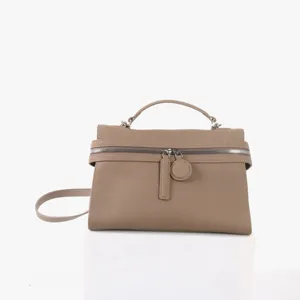 Détail du sac à main en cuir taupe, texture structurée et fermeture à glissière.