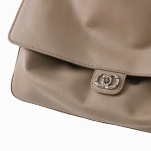 Vue détaillée du rabat de sac à main en cuir souple et fermoir métallique taupe.