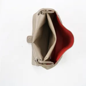 Vue detaillee de l'interieur du sac en cuir souple dote d'une belle doublure rouge.