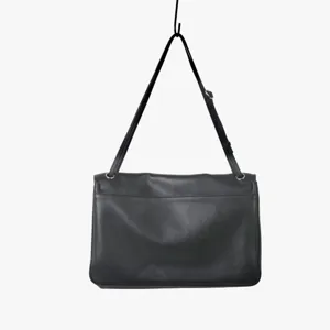 Vue détaillée de la sangle de sac à bandoulière en cuir souple noir avec boucle métal.