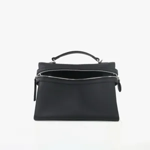 Détail de sac à main noir en cuir véritable avec texture de haute qualité et double zip.