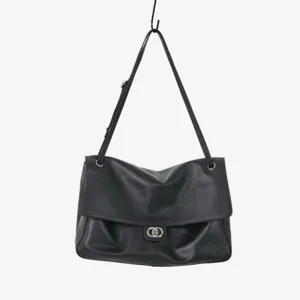 Vue détaillée du sac porté épaule en cuir souple noir avec fermoir métallique élégant.