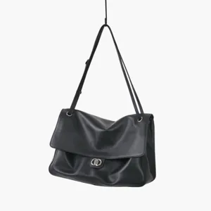 Vue détaillée d'un sac porté épaule en cuir souple noir avec chaîne et fermoir tournant.