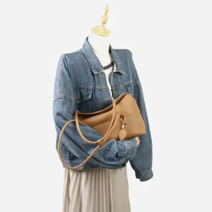 Vue détaillée du sac porté épaule souple en cuir de vachette camel à texture fine.