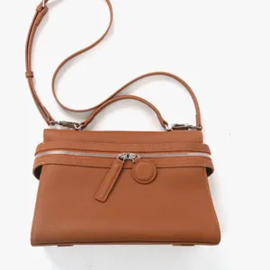 Vue détaillée du sac à main en cuir véritable avec fermeture éclair et bandoulière.