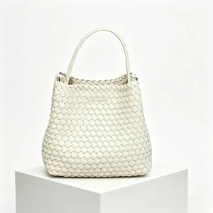 Gros plan sur les détails du sac à main en cuir tissé blanc, texture premium et artisanat.