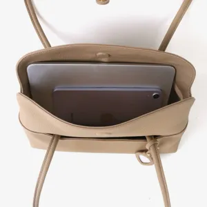 Vue de dessus détaillée de l'intérieur du sac en cuir beige avec grande capacité.