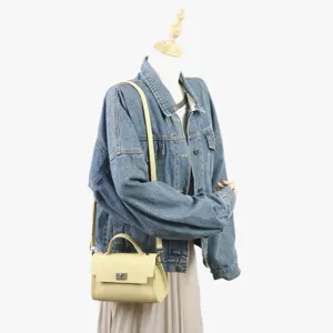 Vue détaillée du sac bandoulière élégant en cuir sur mannequin avec veste en denim.