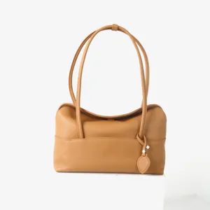 Vue detaillee du sac porte-epaule en cuir tan, mettant en valeur la texture et le design souple.