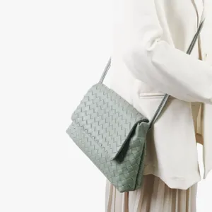 Gros plan detail du sac a bandouliere en cuir tisse vert, superbe artisanat.