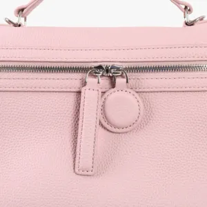Gros plan sur le détail de la fermeture éclair en métal d'un sac à main en cuir rose.